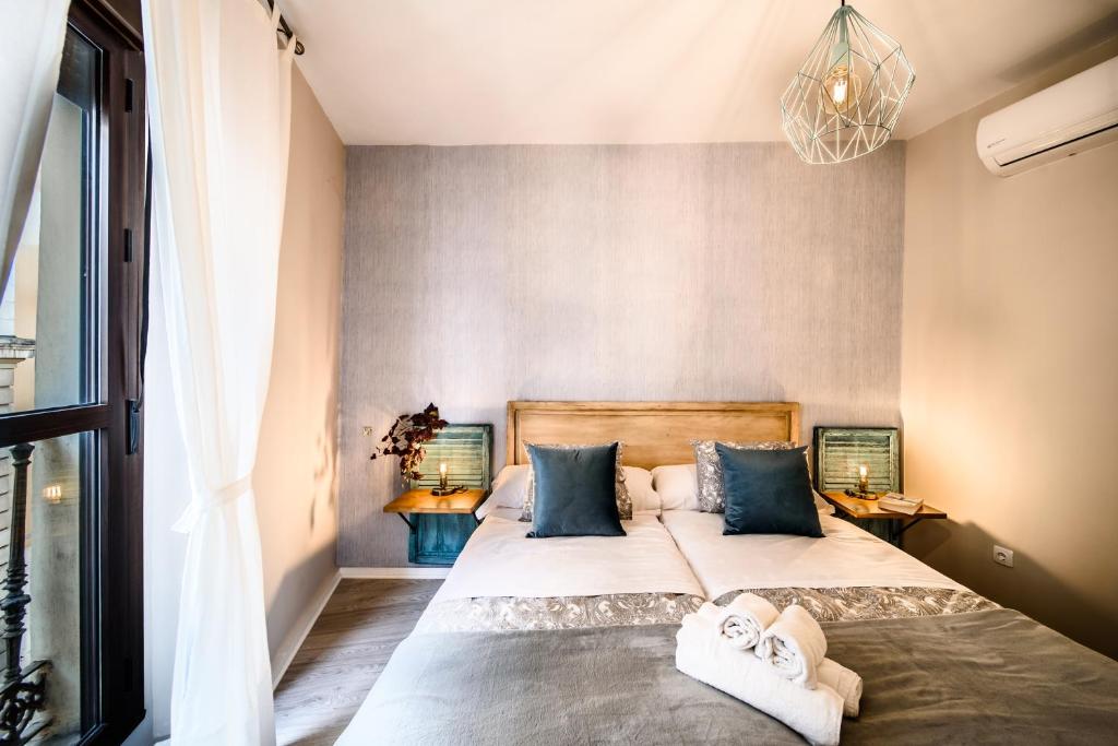 a bedroom with a large bed with blue pillows at Apartamentos San Pedro in Seville