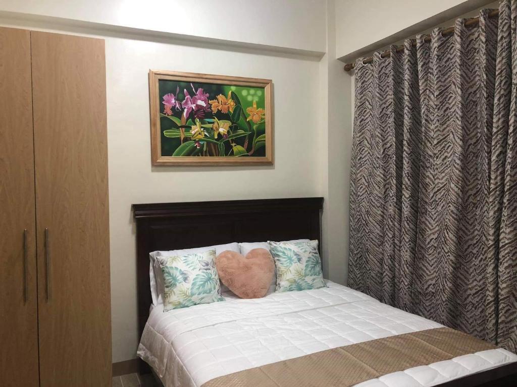 Dormitorio con cama con almohada de corazón en One Madison Place, Tower 2 - 10N MEGAWORLD Iloilo, en Iloilo City