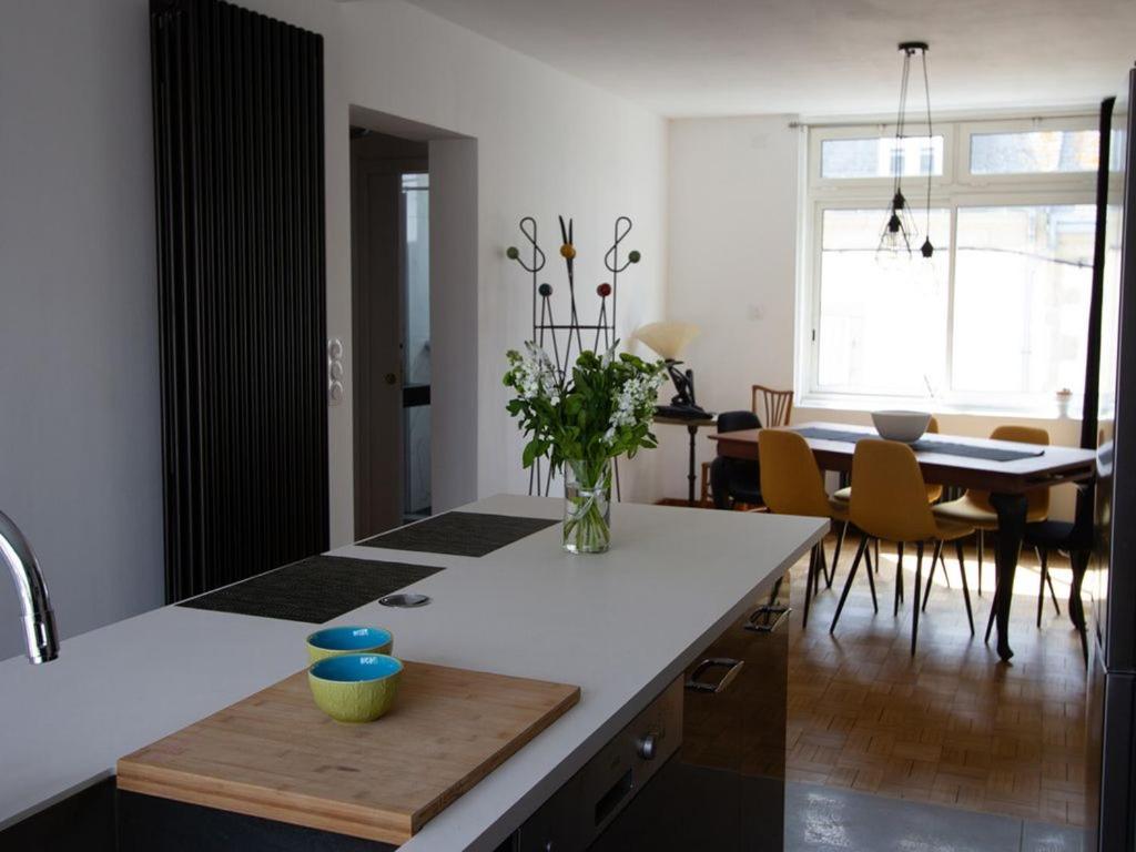 Una cocina y un comedor con mesa y sillas. en Les Aigrettes - Appartement spacieux - Terrasse et garage, en Concarneau
