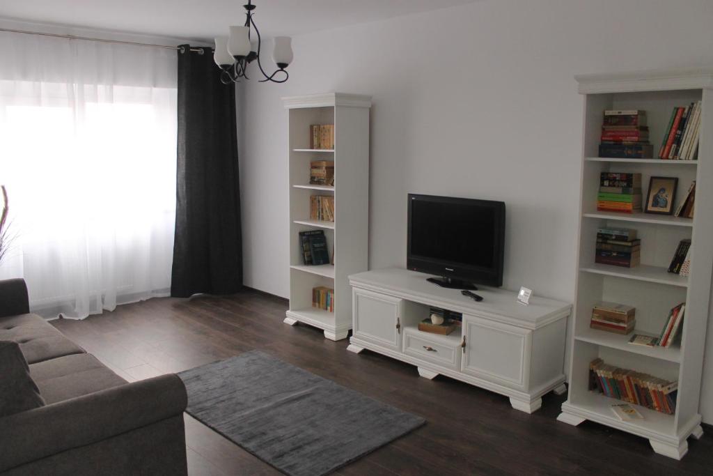 una sala de estar con TV en un centro de entretenimiento blanco en Aparthotel Daria, en Constanţa