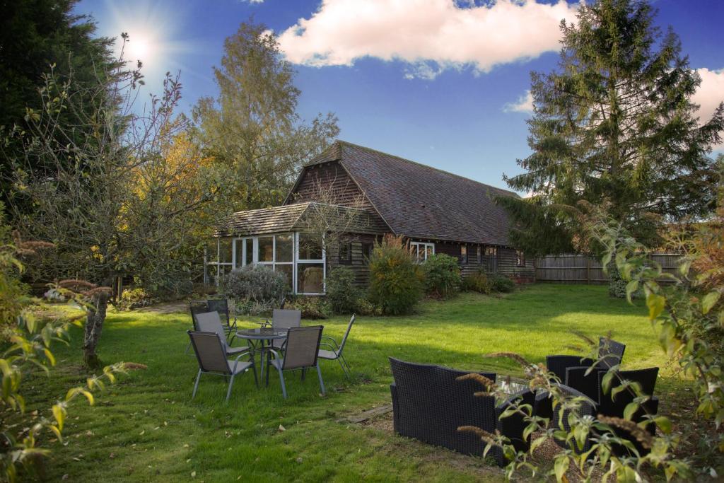 una casa con mesa y sillas en el patio en Landews Meadow Cottages, en Badlesmere