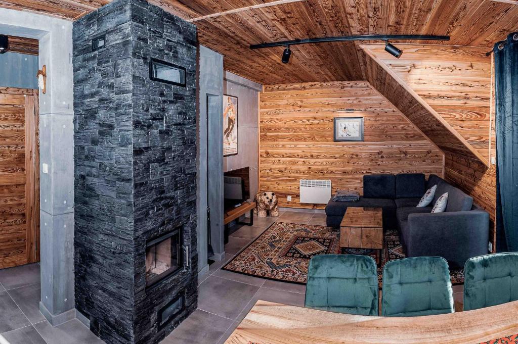 a living room with a stone fireplace in a house at Bury Miś in Jaworki