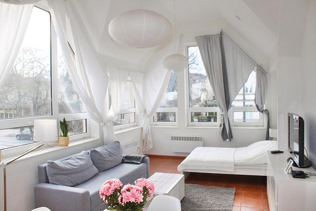 un soggiorno con divano, letto e finestre di Apartament Central Sopot a Sopot