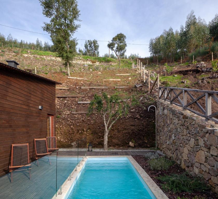 a swimming pool in a yard next to a building at Casa do Avô in Cinfães