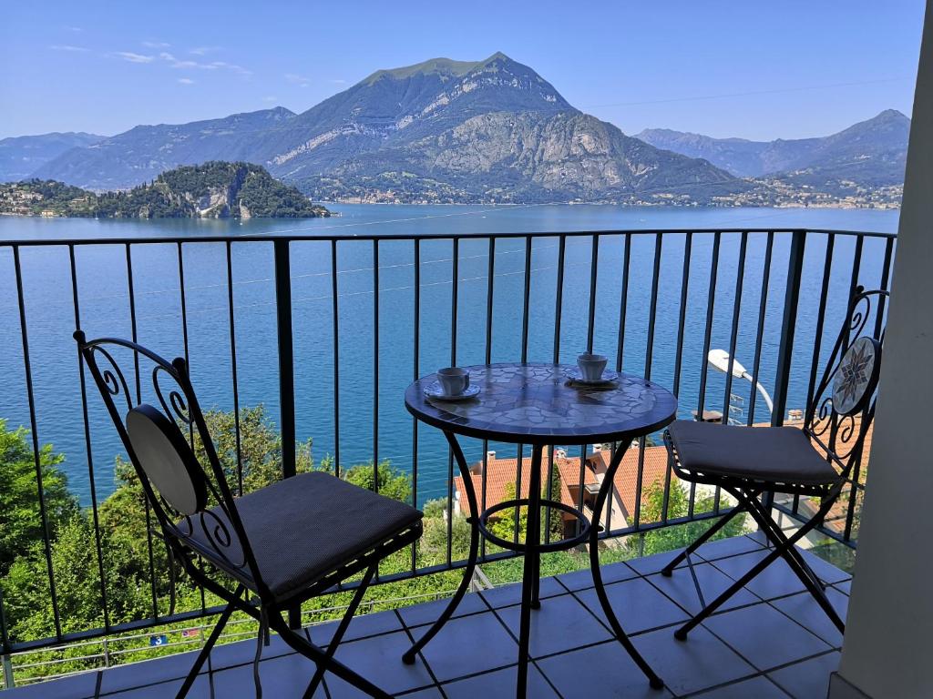 un tavolo e sedie su un balcone con vista sull'acqua di Near Villa Monastero and Castello di Vezio a Varenna