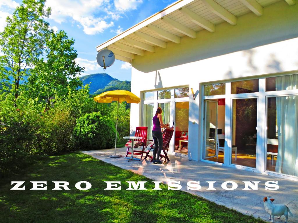 Eine Frau steht auf der Terrasse eines Hauses in der Unterkunft FLORES, Ferienhaus Zimmer, im Grünen, 5 Gehminuten ins Zentrum, Parkplatz, zero emissions in Bad Ischl