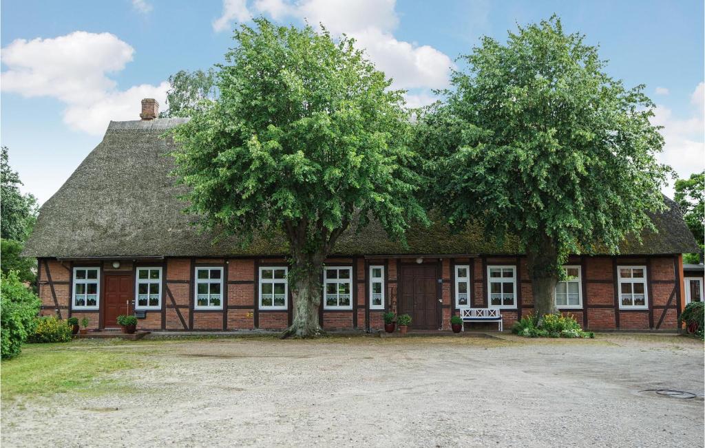ein altes Gebäude mit einem Baum davor in der Unterkunft Beautiful Home In Lutterbek With 3 Bedrooms And Wifi in Lutterbek