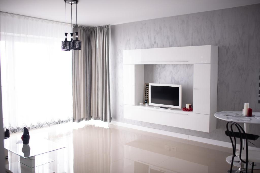 a living room with a television on a wall at Apartament Denissia in Oradea