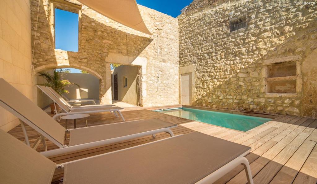 a patio with chairs and a swimming pool at Sa Granada in Manacor