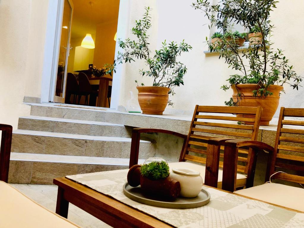 een eetkamer met een tafel met stoelen en potplanten bij Apartment Karin in Rijeka