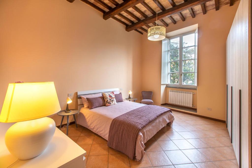 a bedroom with a bed and a lamp and a window at Casa dell'edera P in Orvieto