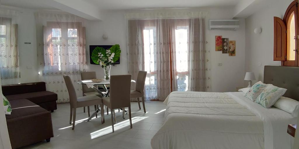 1 dormitorio con 1 cama, mesa y sillas en La Petite Maison, en Taormina