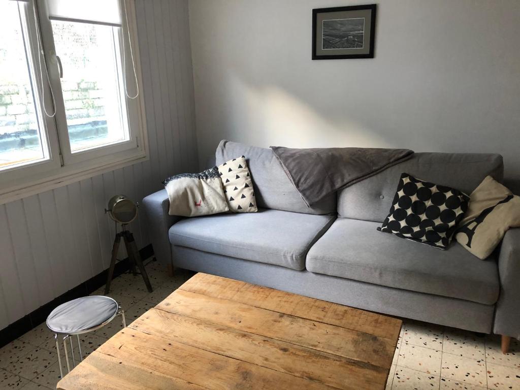 een woonkamer met een bank en een houten salontafel bij Villa Coquelicot Industriel in Le Tréport