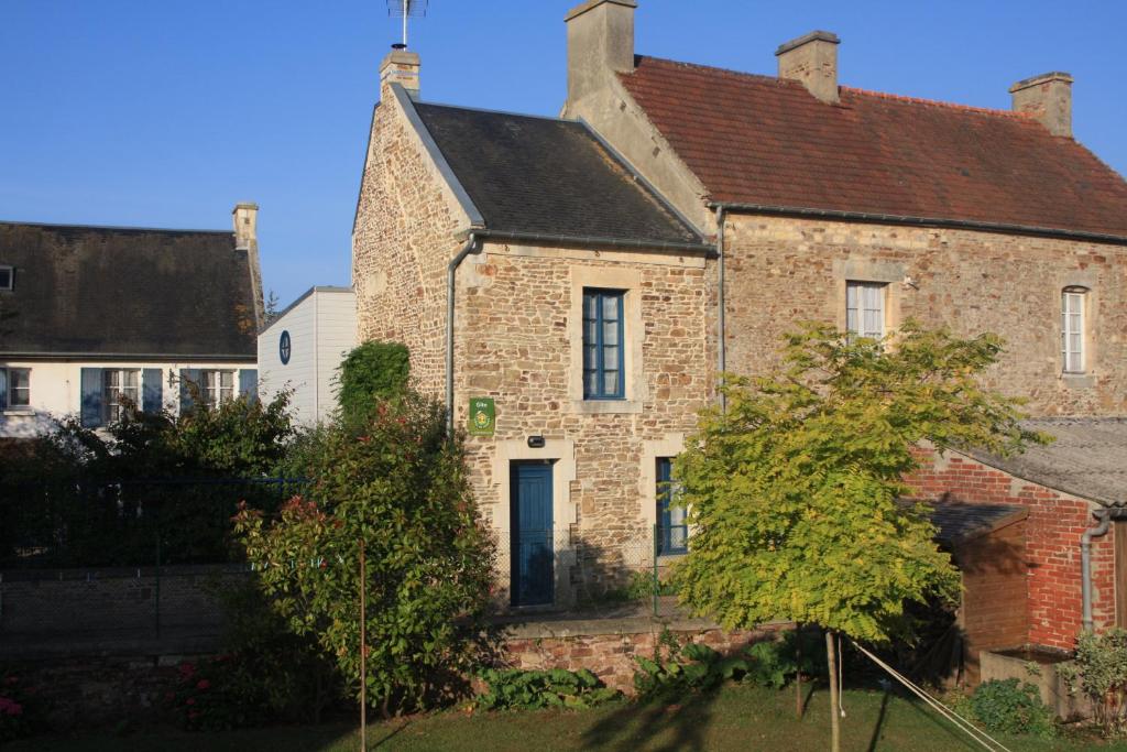 an old brick house with a black roof at la p'tite maison in Feuguerolles-sur-Orne
