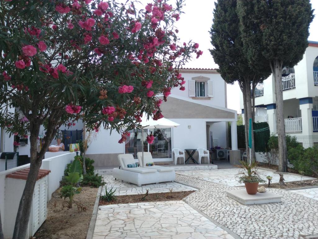 un cortile con fiori rosa su un albero di Wonder Villa ad Albufeira