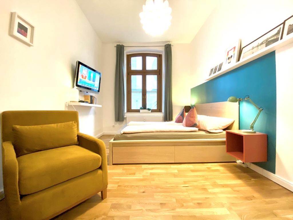 ein Schlafzimmer mit einem Bett, einem Stuhl und einem TV in der Unterkunft Über den Dächern Boppards in Boppard