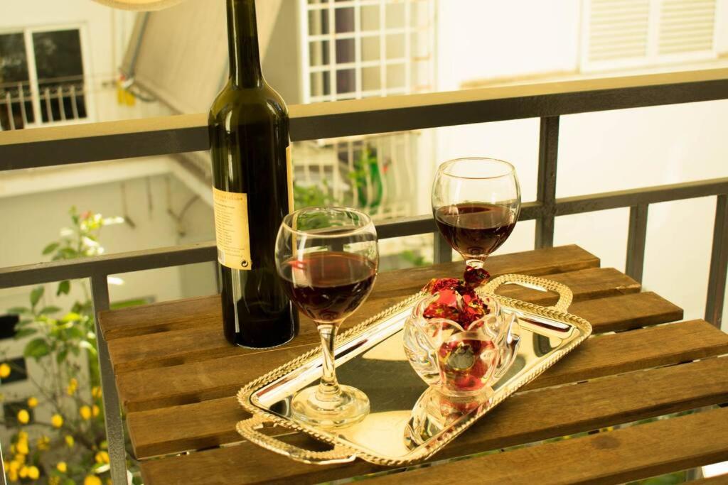 Dois copos de vinho numa mesa com uma garrafa de vinho em Cozy renovated flat in Koukaki em Atenas