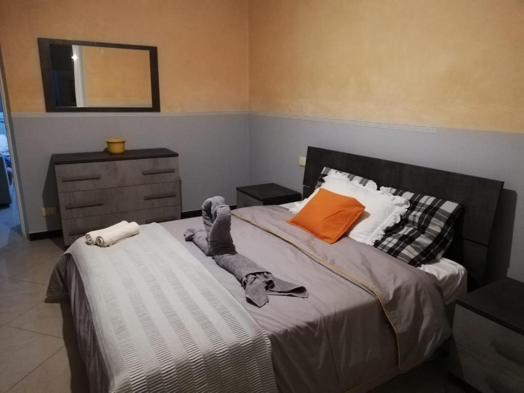 een slaapkamer met een groot bed met een oranje kussen bij Casa vacanze porto antico in Genua