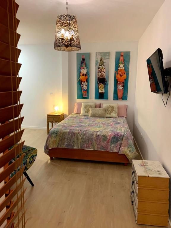 アリカンテにあるEncantador loft en centro tradicionalのベッドルーム1室(ベッド1台付)が備わります。壁には絵画が飾られています。