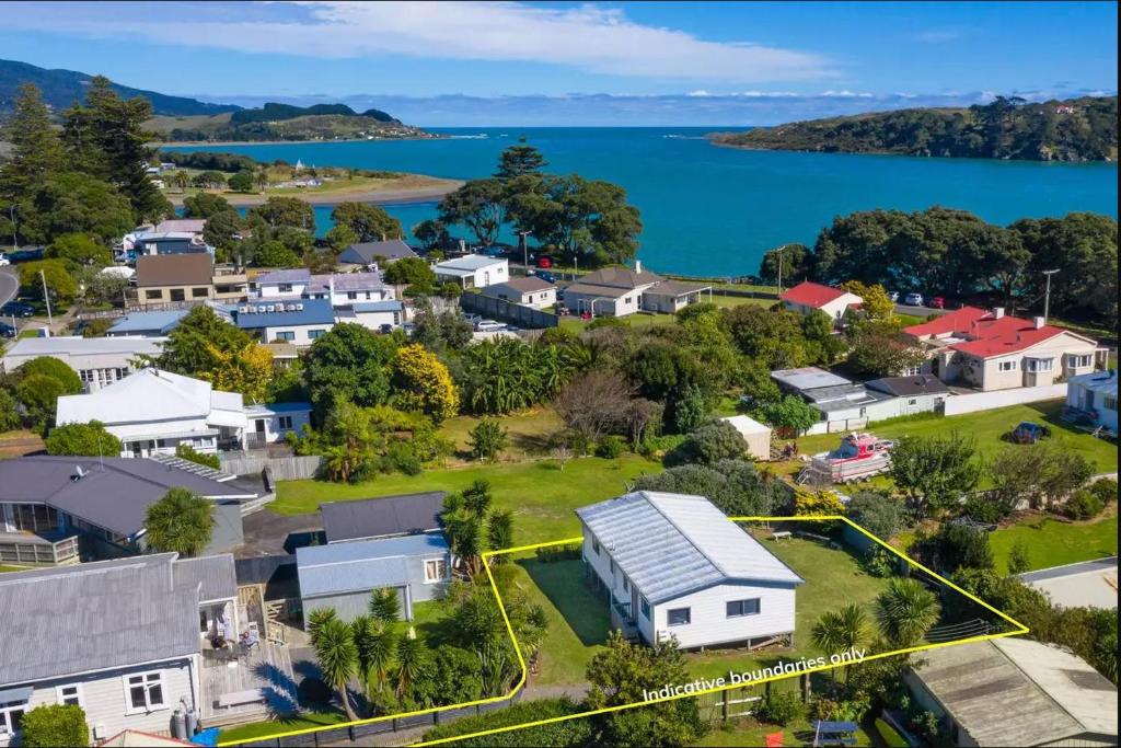 an aerial view of a small town with houses and the water at Raglan beach retreat - 2 bedrooms - with wifi in Raglan