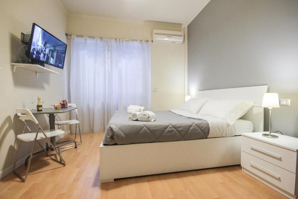 um quarto com uma cama, uma secretária e uma televisão em Le Piazze di Roma Sweet Apartment em Roma