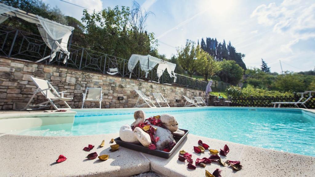 ein Teddybär, der in einem Koffer neben einem Pool sitzt in der Unterkunft Villa Nuba, residenza del Pinturicchio con terrazza panoramica privata, camino a legna,jacuzzi in Perugia