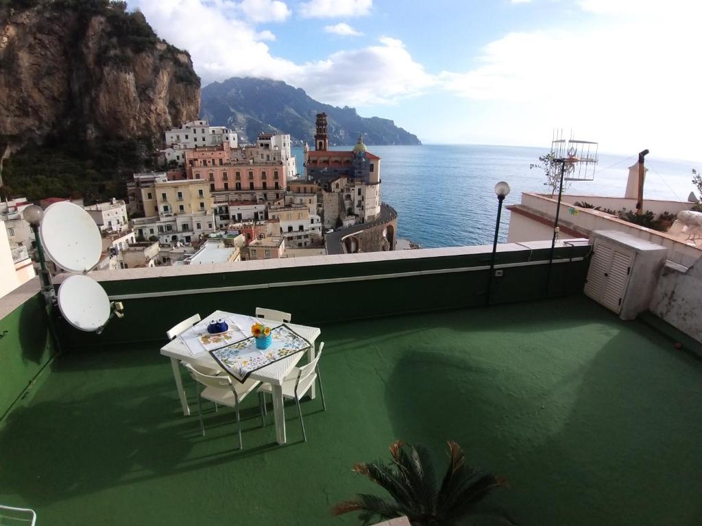 un tavolo e sedie su un balcone con vista sull'oceano di Casa Eden ad Atrani