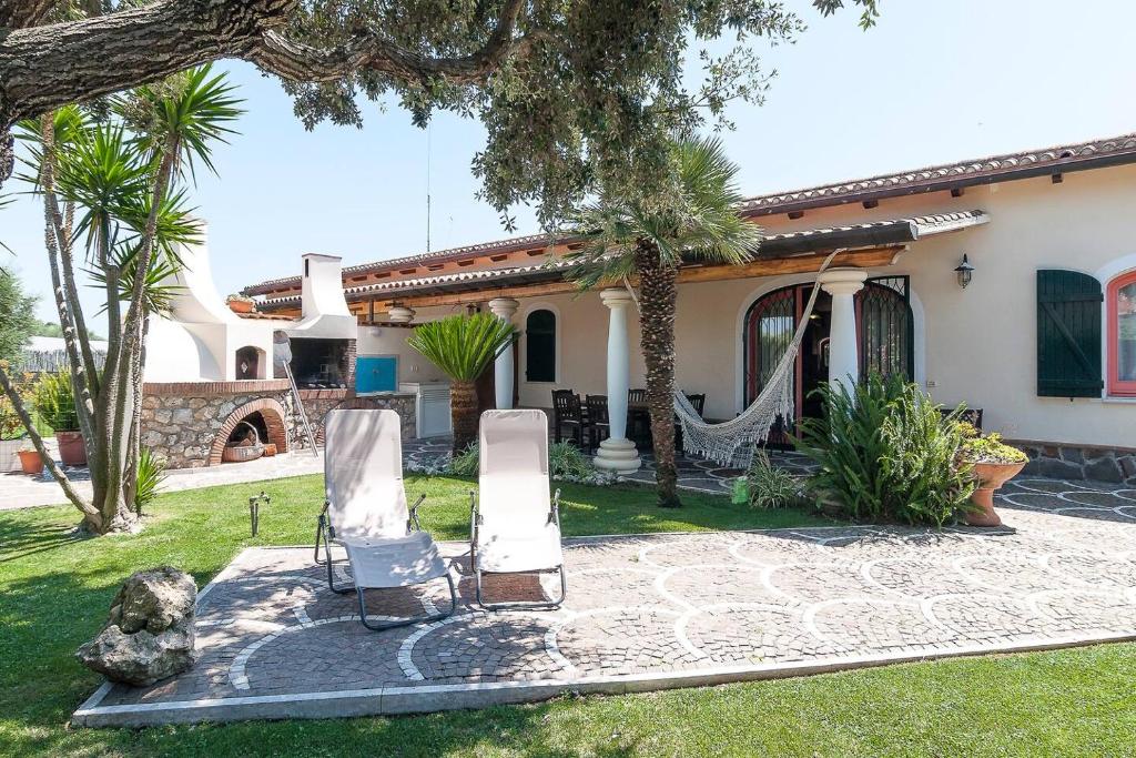a house with two lounge chairs in the yard at La Cesa Case Vacanza in San Felice Circeo