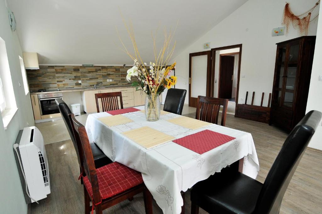 a dining room table with a vase of flowers on it at Apartment Fiorenini 2 in Mlini