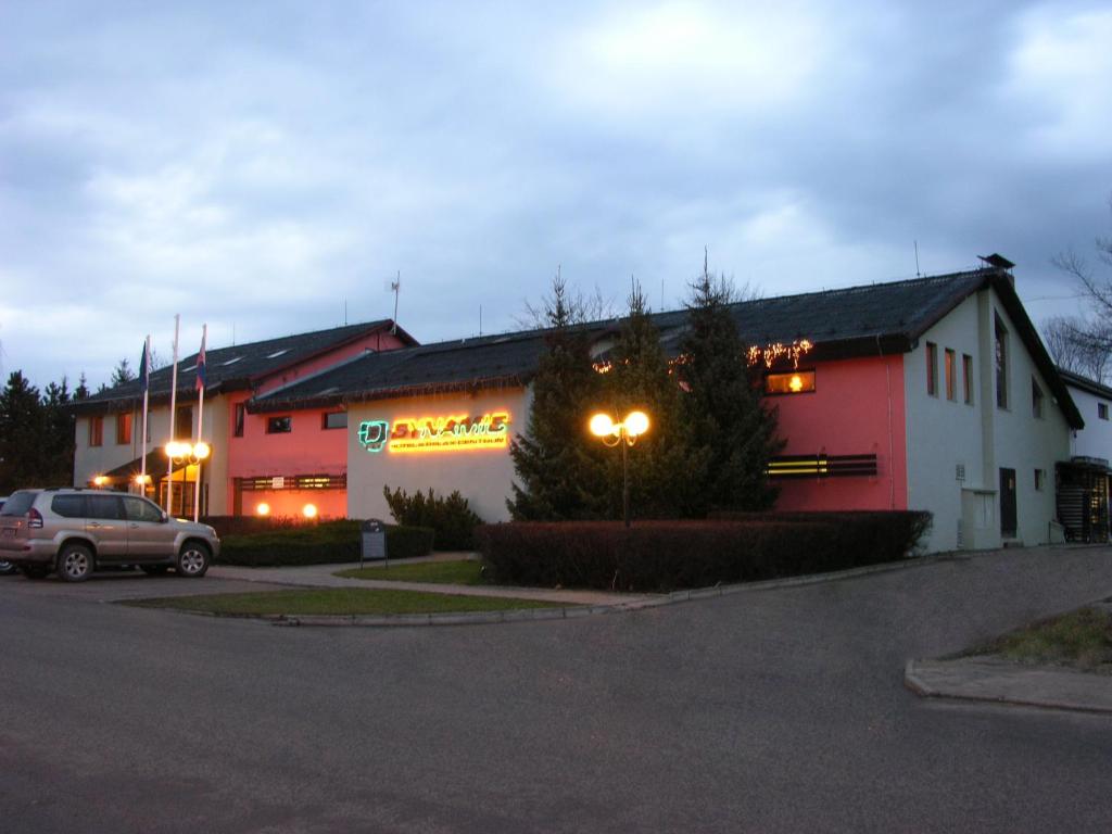 ein Gebäude mit einem Auto auf einem Parkplatz in der Unterkunft Hotel Dynamic in Nová Dubnica