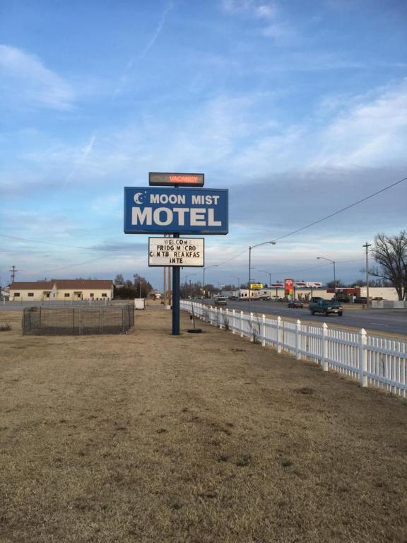 un panneau indiquant le premier motel lune à côté d'une clôture dans l'établissement Moon Mist Motel, à Meade