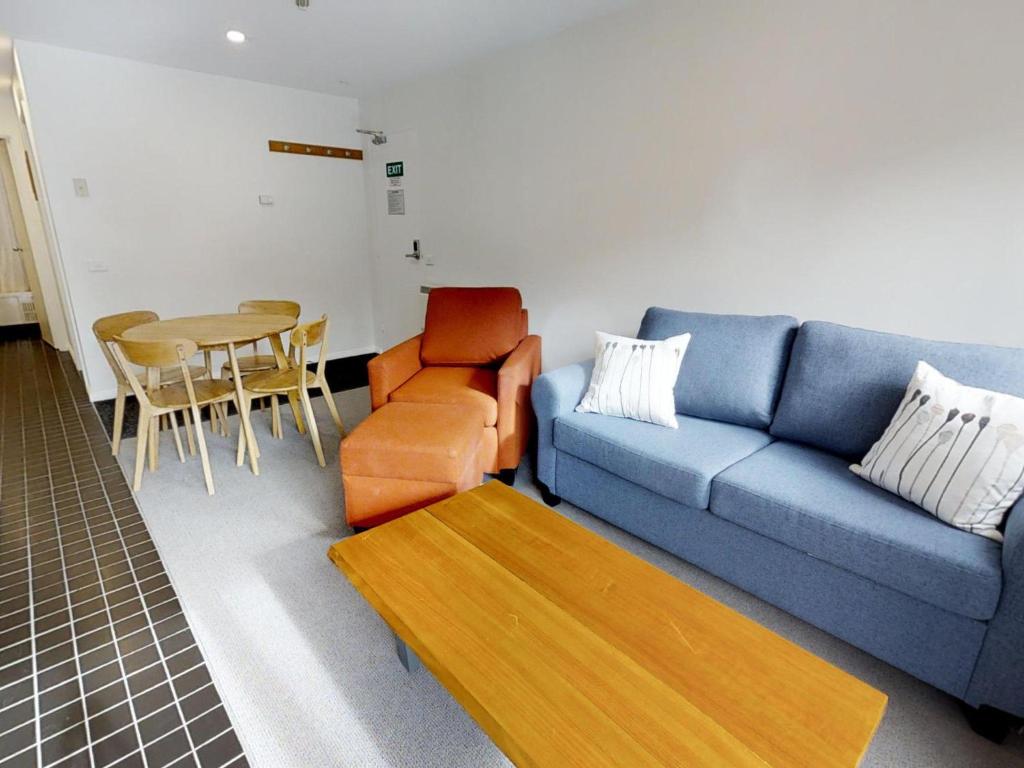 sala de estar con sofá azul y mesa en Apartment 11 The Stables Perisher, en Perisher Valley