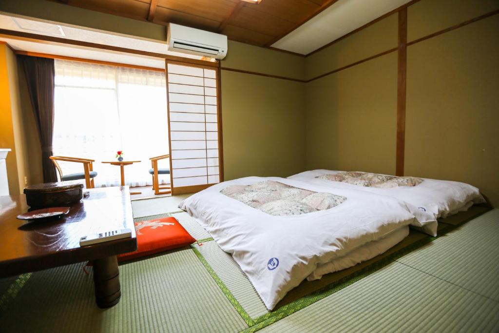Postel nebo postele na pokoji v ubytování Rakki OnsenRyokan 楽奇温泉旅館