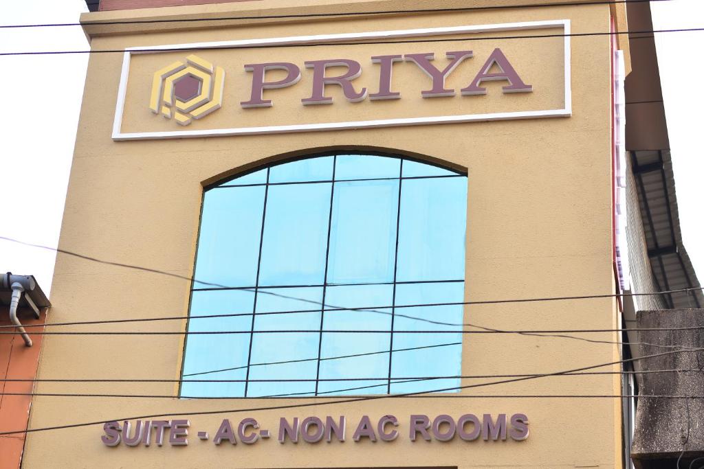 a sign on the side of a building with a window at Hotel Priya in Kottakkal