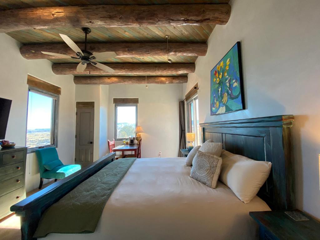 - une chambre avec un grand lit et un ventilateur de plafond dans l'établissement The Grand Hacienda Estate with Breakfast, à Abiquiu