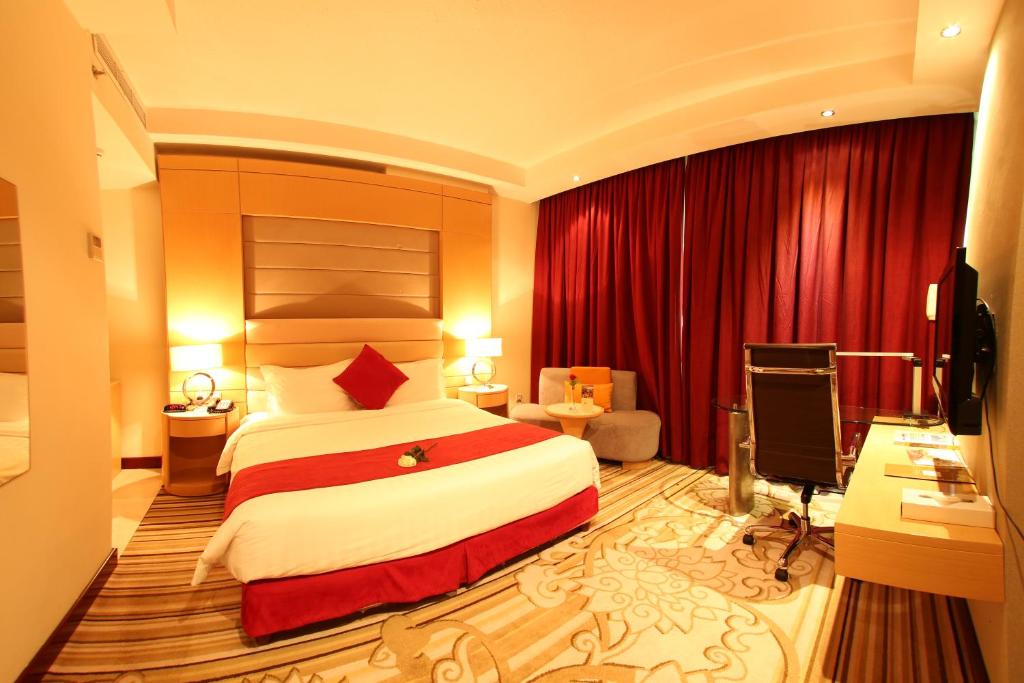a hotel room with a bed and a desk at Coral Olaya Hotel in Riyadh
