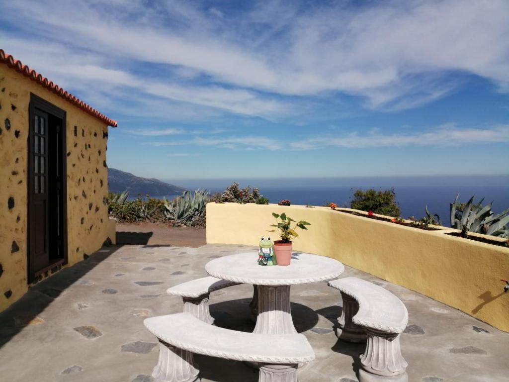 einen Tisch und Stühle auf einer Terrasse mit Meerblick in der Unterkunft Los Frailes in Breña Baja