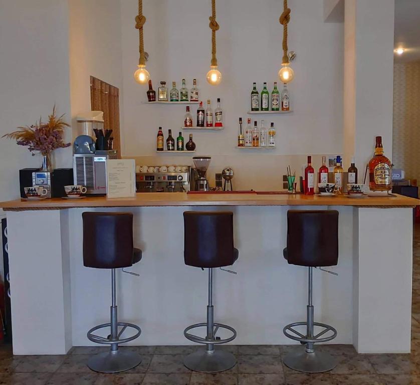 a bar with three bar stools in a room at Asteri Hotel in Livadi