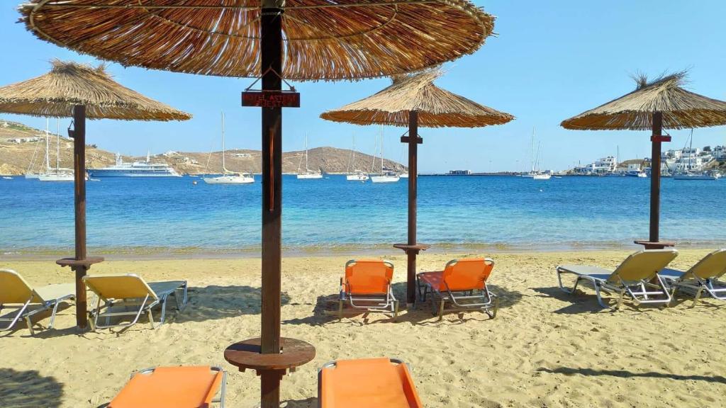 a group of chairs and umbrellas on a beach at Asteri Hotel in Livadi