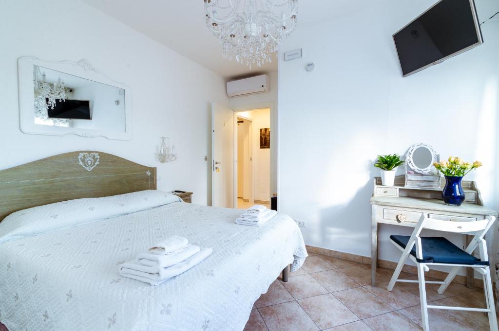 a white bedroom with a bed and a desk at "6 in centro" guest house in Sanremo