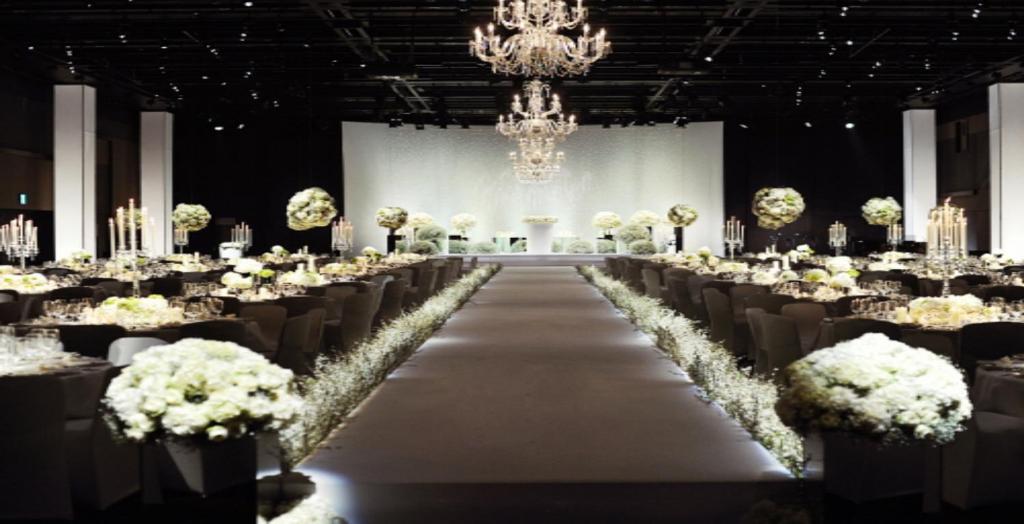 a banquet hall with a long aisle with white flowers at The Shilla Seoul in Seoul