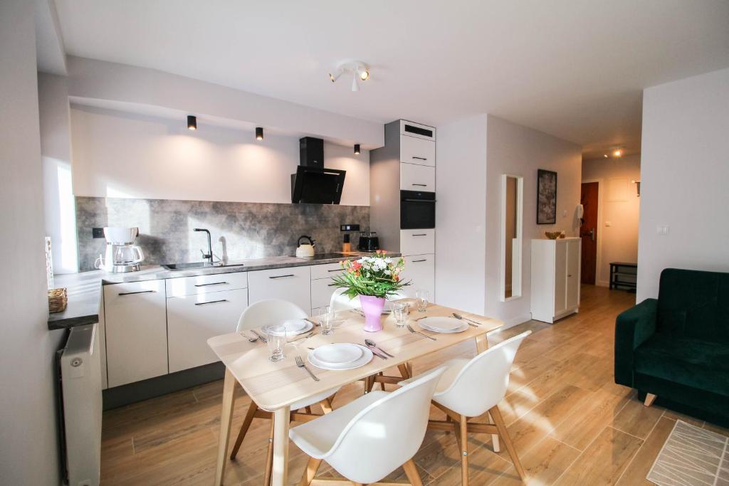 a kitchen and dining room with a table and chairs at Aparthotel City Center Apartments in Krynica Zdrój