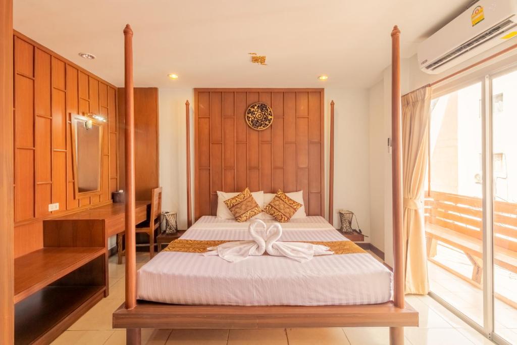 a bedroom with a bed with a bow on it at Lotus Hotel Patong in Patong Beach