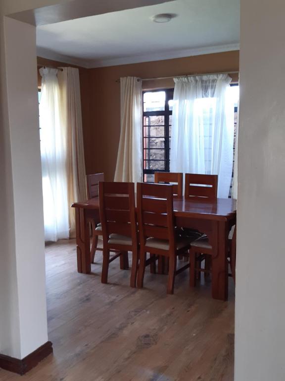 a dining room with a wooden table and chairs at El Sueno Homestay in Naivasha