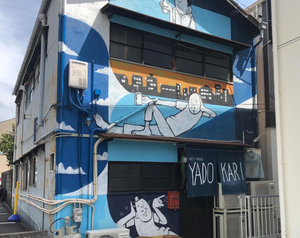 a building with a mural on the side of it at Yadokari House in Okayama
