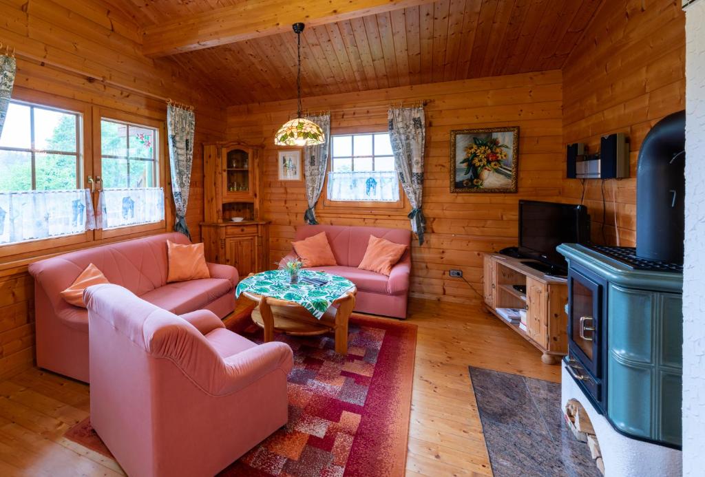 ein Wohnzimmer mit Sofas und einem Tisch in einer Hütte in der Unterkunft Ferienhaus Vogelsang in Bad Sooden-Allendorf in Bad Sooden-Allendorf