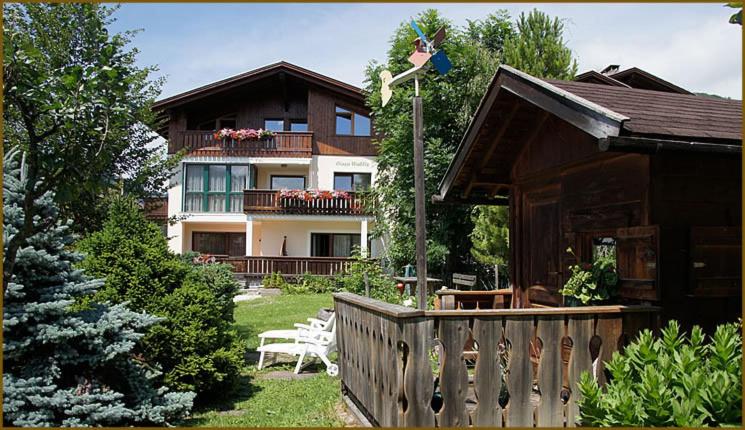 una casa con una valla de madera en el patio en Ciasa Wallis, en Badia