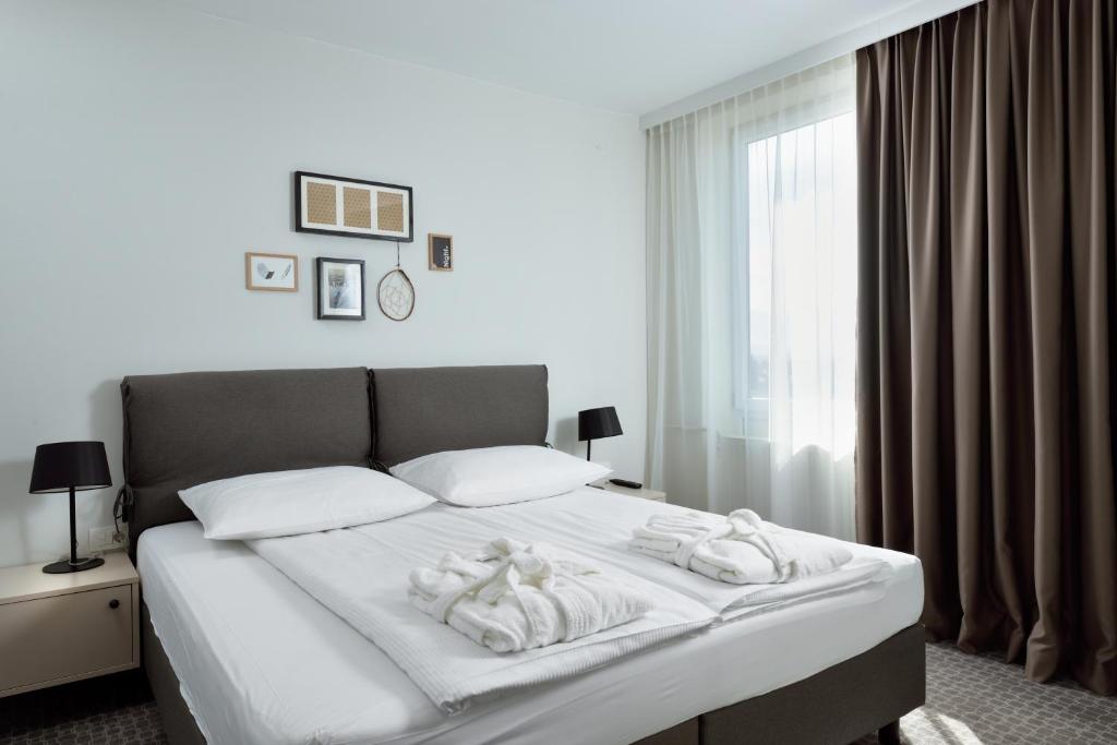 a bedroom with a bed with towels on it at B&B Hotel Ljubljana Park in Ljubljana