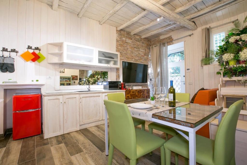 a kitchen with a dining table and green chairs at ROUTE 66 SPA in Vignanello