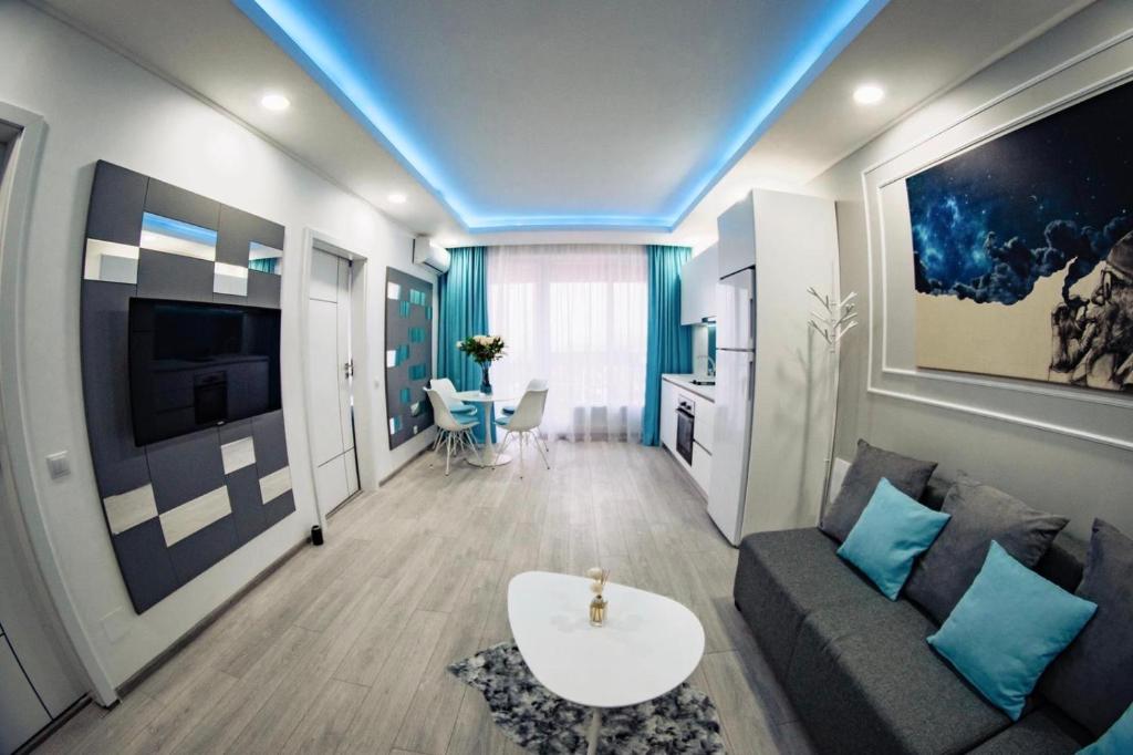 オラデアにあるTurcoazLux apartmentsのソファとテーブルのあるリビングルーム